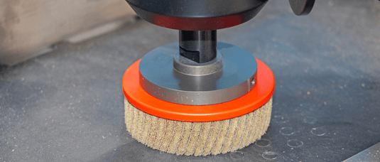 Polishing machine with a brush attachment on a concrete surface