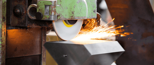 Industrial grinder for stainless steel polishing in use with sparks flying