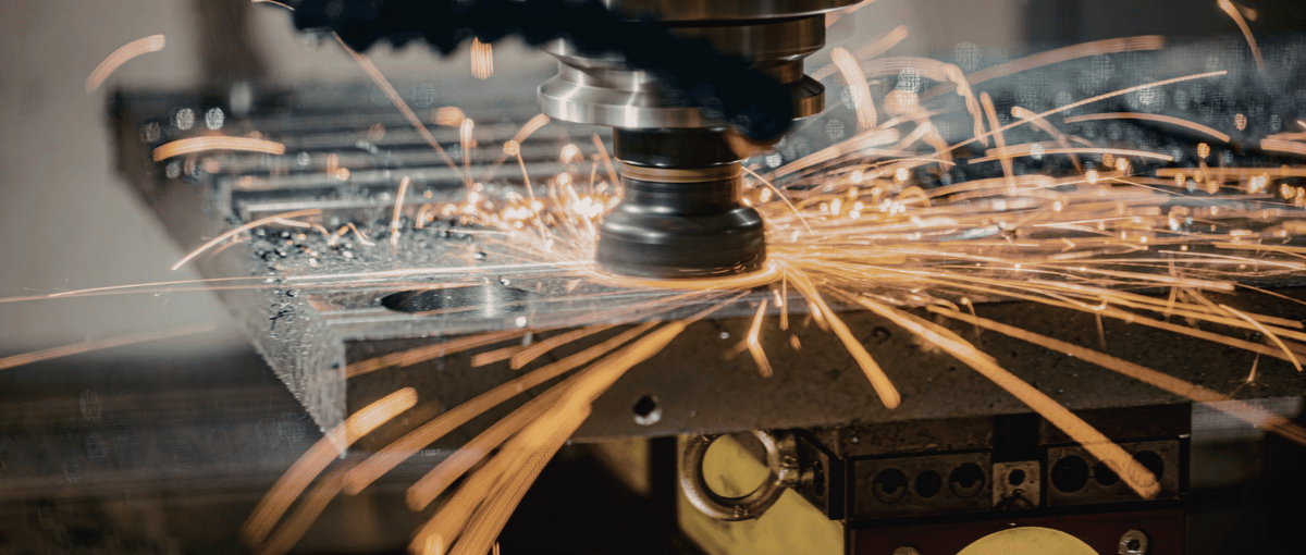 CNC machine cutting metal with sparks flying
